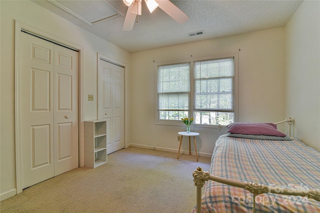 carpeted bedroom featuring a textured ceiling and ceiling fan