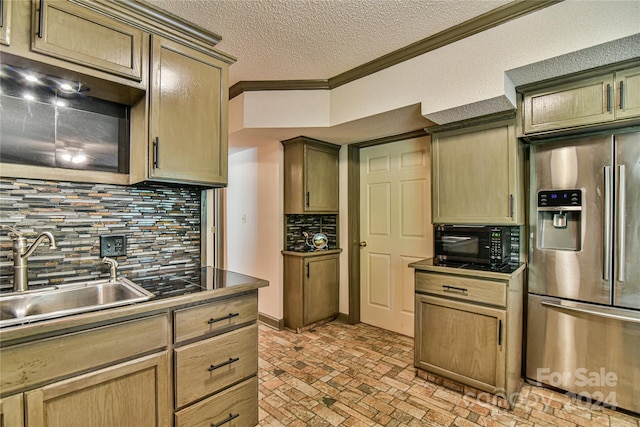 kitchen featuring crown molding, a textured ceiling, tasteful backsplash, stainless steel fridge, and sink