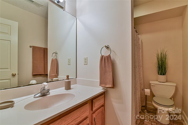 bathroom featuring toilet, tile floors, vanity, and a textured ceiling