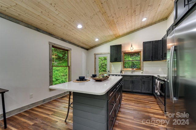 kitchen featuring wood ceiling, vaulted ceiling, appliances with stainless steel finishes, a kitchen island, and backsplash