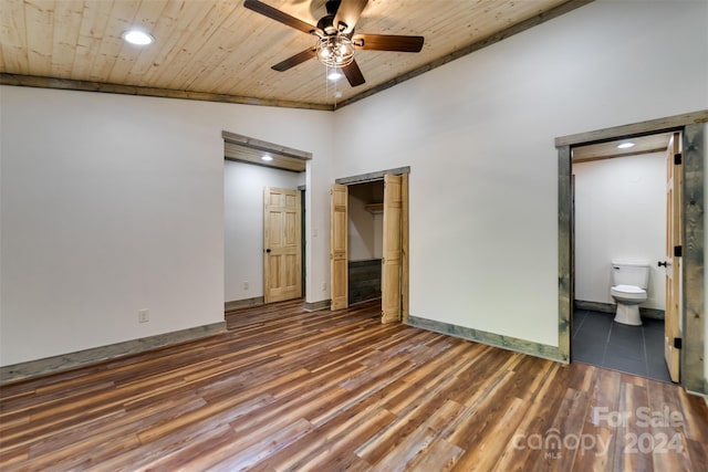 unfurnished bedroom with wood ceiling, a closet, ensuite bath, ceiling fan, and dark wood-type flooring