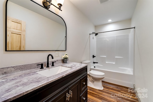 full bathroom with toilet,  shower combination, vanity, and hardwood / wood-style flooring