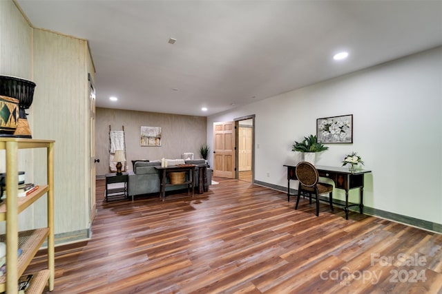 office area with dark hardwood / wood-style flooring and wooden walls