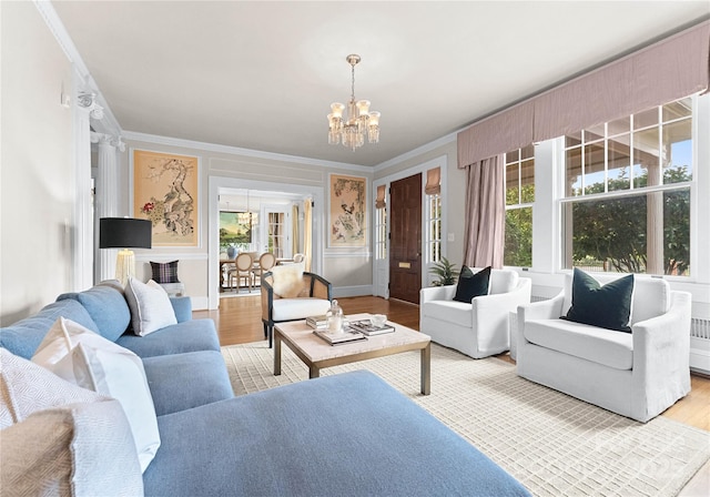 living room with hardwood / wood-style flooring, crown molding, and a chandelier