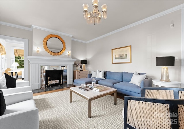 living room with wood-type flooring, crown molding, a tile fireplace, and an inviting chandelier