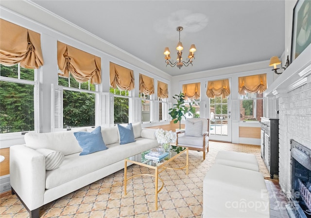 sunroom / solarium with a chandelier and a brick fireplace