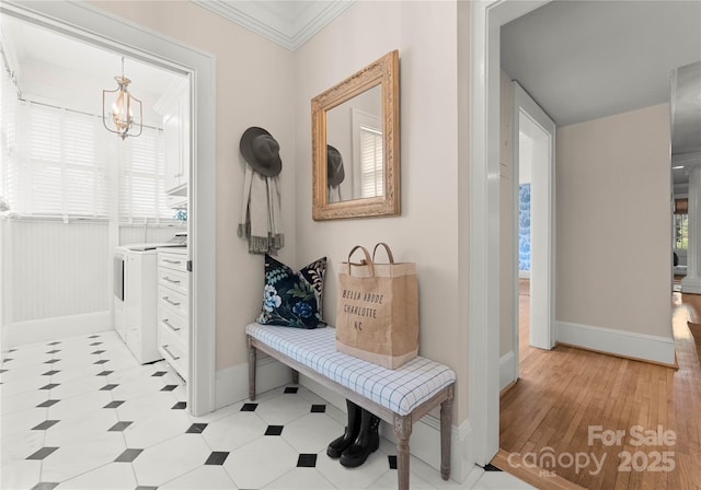 mudroom with washing machine and dryer, an inviting chandelier, a wealth of natural light, and ornamental molding