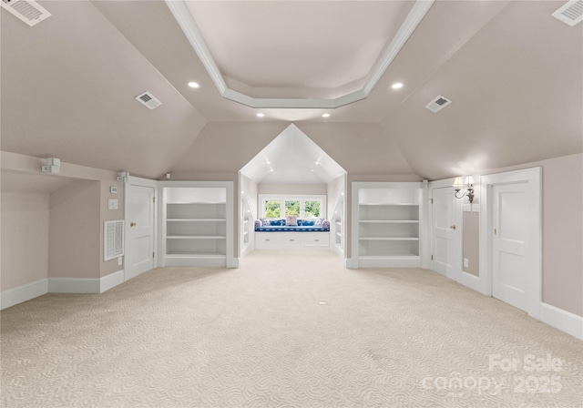 bonus room with built in shelves, light colored carpet, and vaulted ceiling