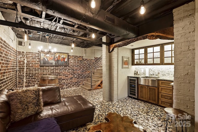 wine cellar featuring an inviting chandelier, wine cooler, wet bar, and brick wall