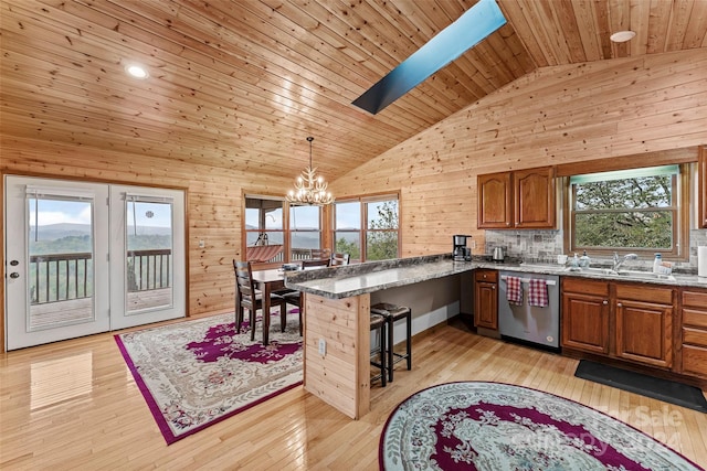 kitchen with a healthy amount of sunlight, light hardwood / wood-style floors, and stainless steel dishwasher