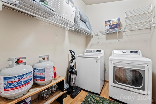 laundry room featuring light wood-type flooring and washer and clothes dryer