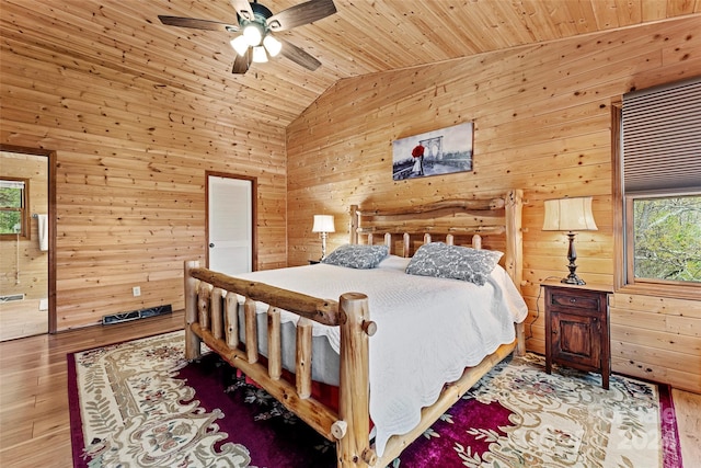 bedroom with hardwood / wood-style flooring, wood walls, wood ceiling, and ceiling fan