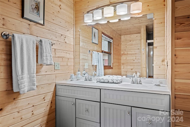 bathroom featuring wooden ceiling, wood walls, and dual bowl vanity