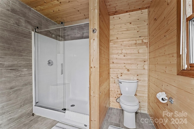 bathroom featuring wooden walls, a shower with shower door, toilet, and wood ceiling