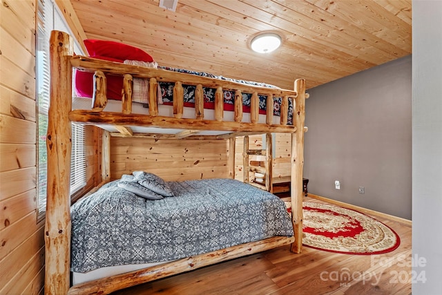 bedroom featuring wood walls, wooden ceiling, and hardwood / wood-style floors