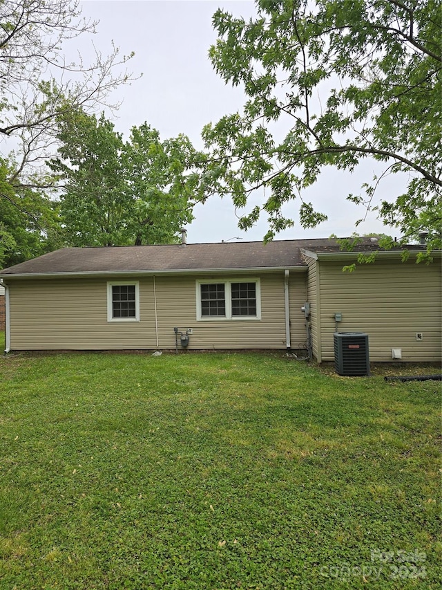 back of property featuring a yard and central AC unit