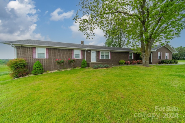 ranch-style home with a front lawn