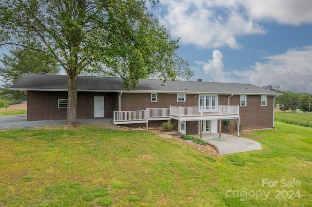 back of house featuring a patio, a lawn, and a deck