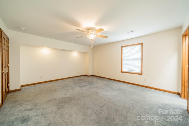 empty room featuring ceiling fan and carpet