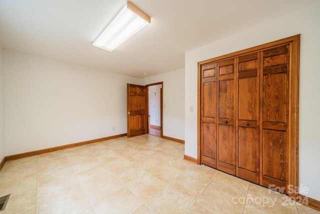 unfurnished bedroom featuring a closet and light tile floors