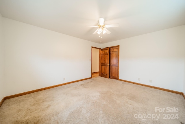 carpeted spare room with ceiling fan