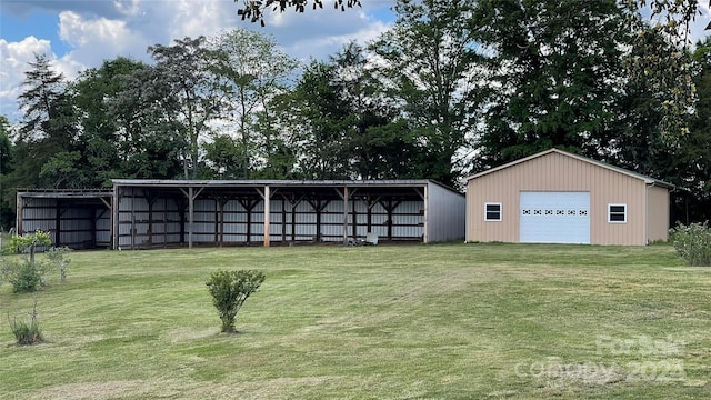 rear view of property featuring an outdoor structure, a garage, and a lawn