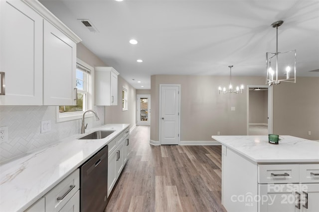 kitchen featuring white cabinetry, dishwasher, sink, hanging light fixtures, and light hardwood / wood-style floors