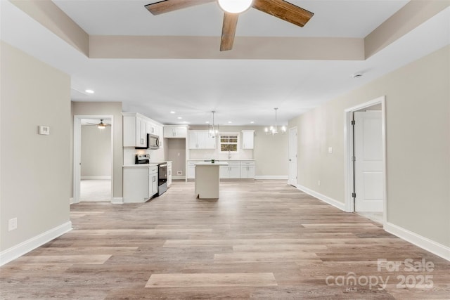 unfurnished living room featuring a chandelier and light wood-type flooring