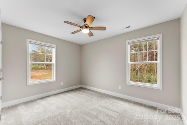 empty room with light carpet, plenty of natural light, and ceiling fan