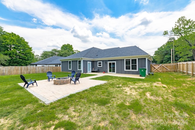 rear view of house featuring a lawn, a fire pit, and a patio