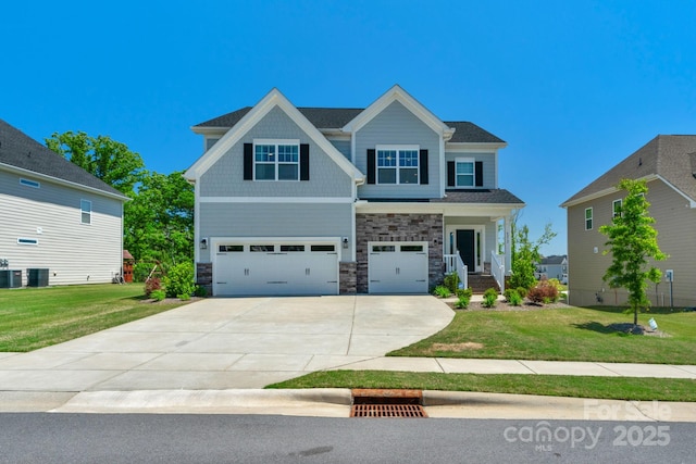 craftsman house featuring central air condition unit, a front yard, and a garage