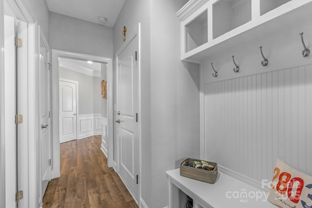 mudroom with ornamental molding and dark hardwood / wood-style floors