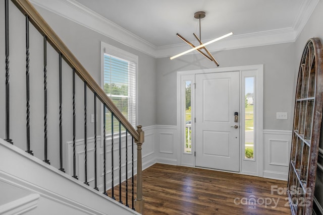 entryway featuring dark hardwood / wood-style flooring, crown molding, and an inviting chandelier