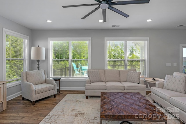 living room featuring ceiling fan and dark wood-type flooring