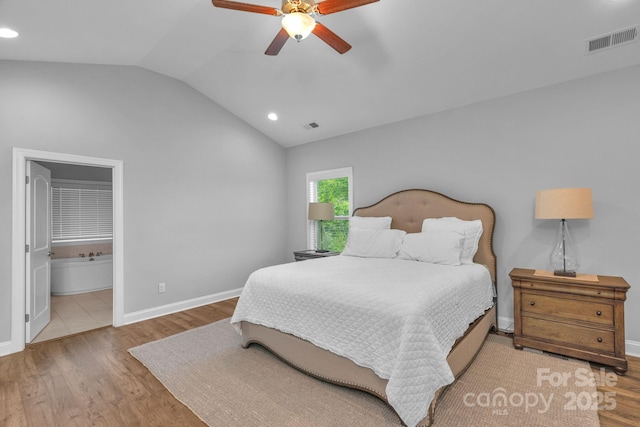 bedroom featuring ceiling fan, vaulted ceiling, hardwood / wood-style flooring, and ensuite bath