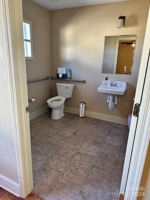 bathroom featuring toilet, ceiling fan, and sink