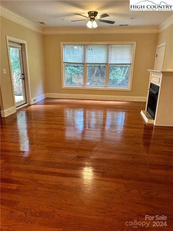 unfurnished living room with ceiling fan, dark hardwood / wood-style flooring, and crown molding