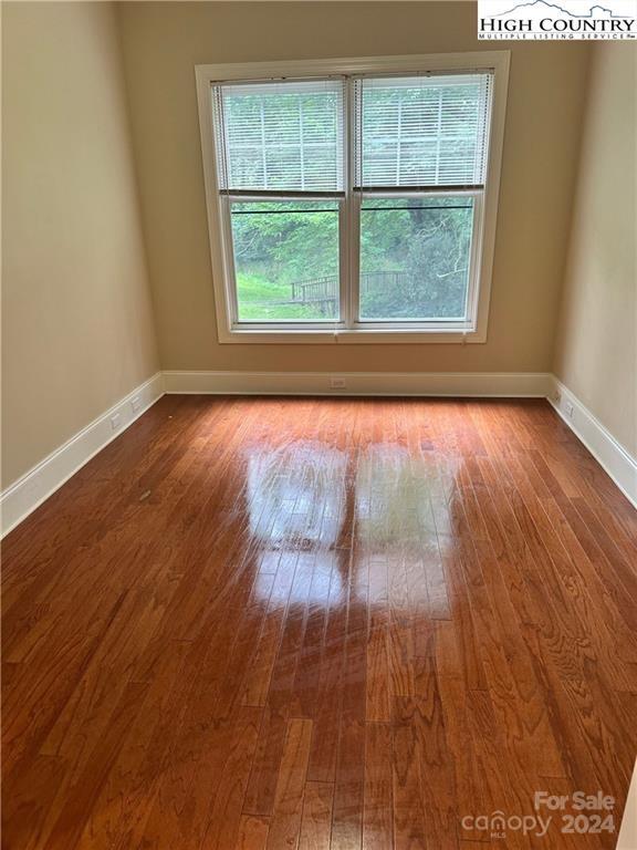 empty room with plenty of natural light and wood-type flooring