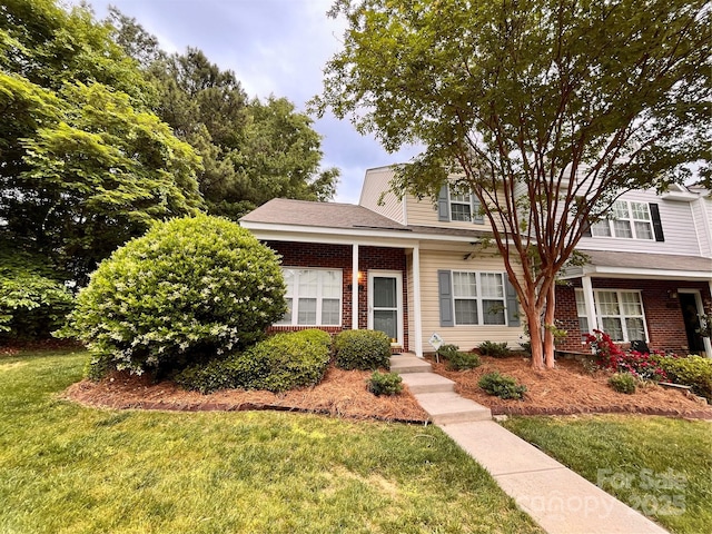 view of front facade with a front yard and brick siding