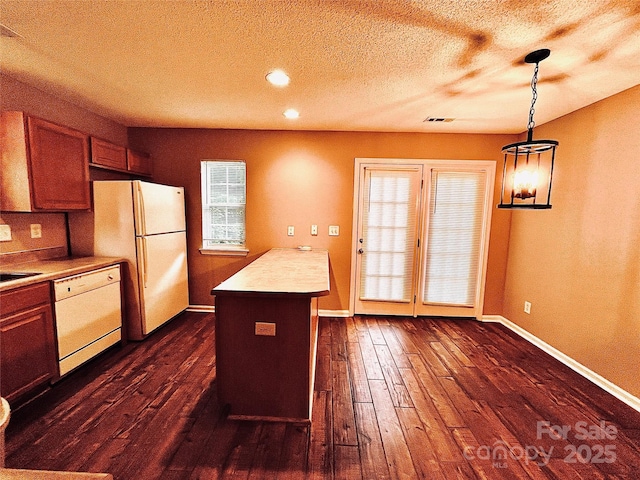 kitchen with white appliances, a textured ceiling, dark wood finished floors, baseboards, and light countertops