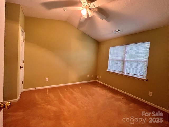 carpeted spare room featuring vaulted ceiling, a ceiling fan, and baseboards