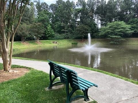 view of community featuring a water view and a yard