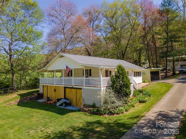 view of side of property featuring a lawn and covered porch