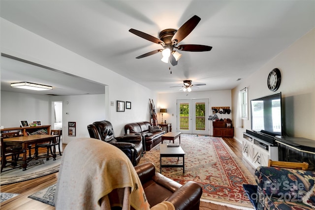 living room featuring hardwood / wood-style floors, ceiling fan, and french doors