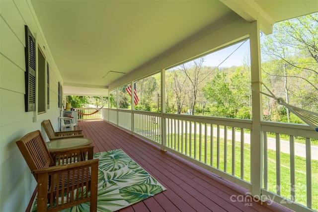 wooden deck with covered porch and a yard