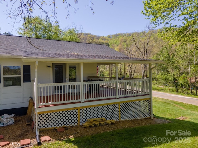 wooden terrace with covered porch and a yard