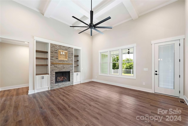 unfurnished living room featuring beamed ceiling, dark hardwood / wood-style floors, and built in shelves