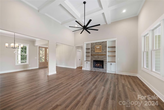 unfurnished living room featuring coffered ceiling, crown molding, beam ceiling, a fireplace, and dark hardwood / wood-style floors