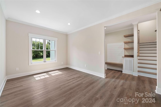 empty room featuring dark wood-type flooring and ornamental molding