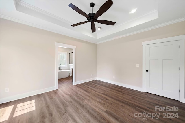 spare room featuring a raised ceiling, hardwood / wood-style flooring, ceiling fan, and ornamental molding